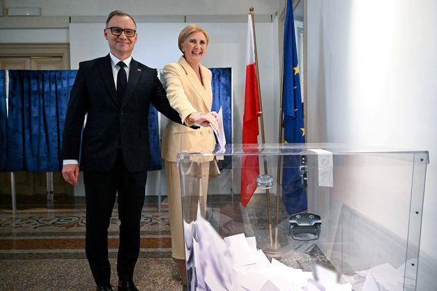 Andrzej Duda i Agata Konrhauser-Duda wrzucają głosy do urny.